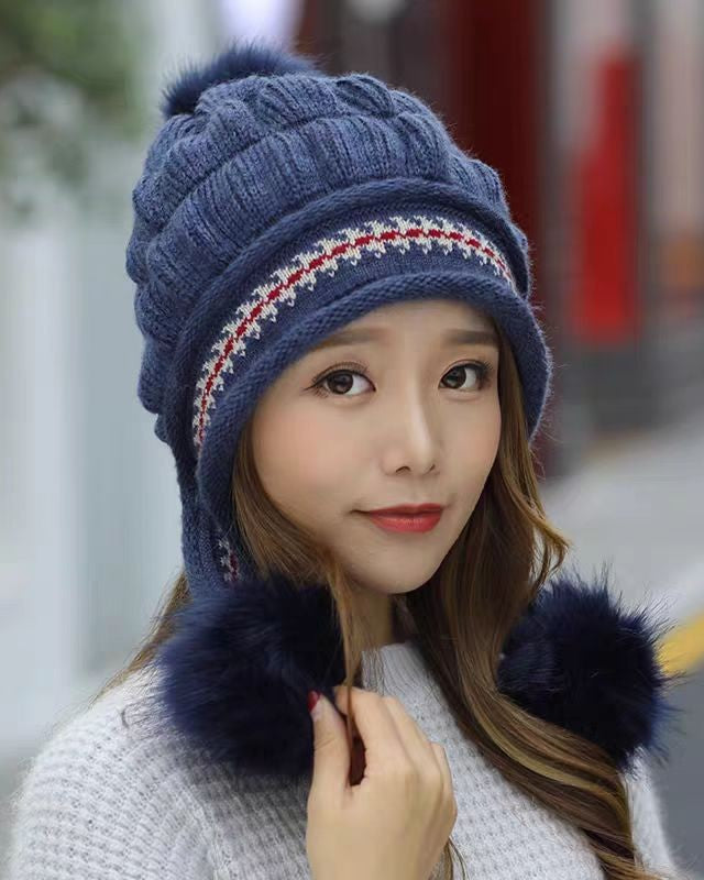 Woman in an ear flap beanie with pompom