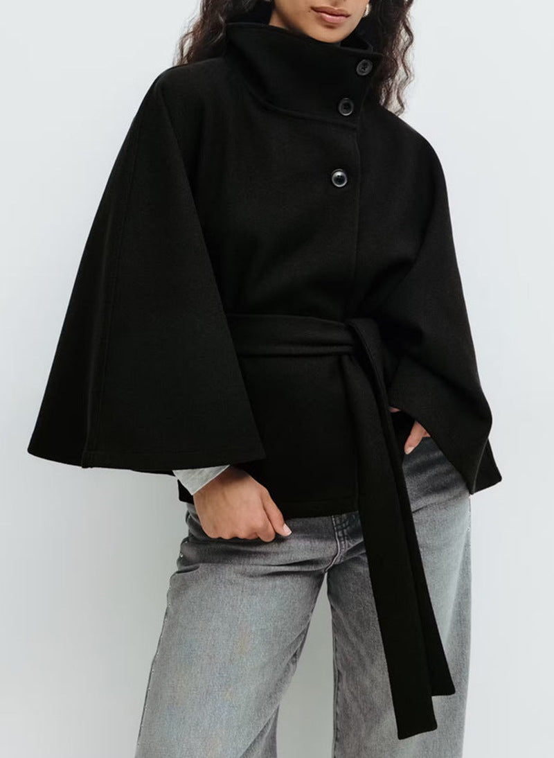 Woman in belted cape coat with high collar