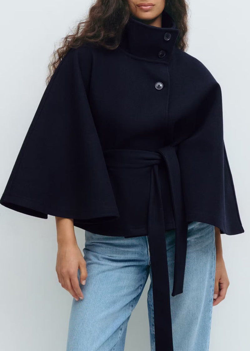 Woman in belted cape coat with high collar