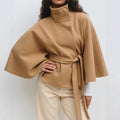 Woman in belted cape coat with high collar